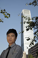 Portrait of young man standing in front of skyscraper, China - Alex Mares-Manton