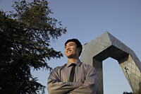 Young man standing in front of CCTV Building, Beijing, China - Alex Mares-Manton