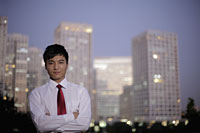 Young man standing in front of buildings in the evening, China - Alex Mares-Manton