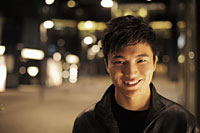 Young man smiling on the street at night - Alex Mares-Manton