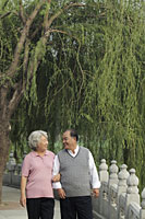 Older couple walking arm and arm in a park - Alex Mares-Manton