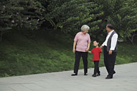 Older couple walking with grandson in the park - Alex Mares-Manton