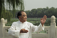 Older man doing Tai Chi in a park, Beijing, China - Alex Mares-Manton