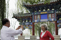 Older couple taking photos in front of traditional Chinese gate - Alex Mares-Manton