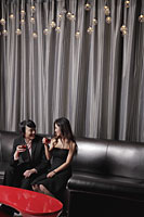 Young couple sitting in a club having a drink - Alex Mares-Manton