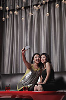 Two women taking photos of themselves in a club - Alex Mares-Manton