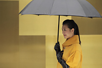 Young woman in coat and gloves holding an umbrella - Alex Mares-Manton