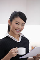 Head shot of young woman holding papers and coffee cup - Alex Mares-Manton