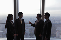 Four businesspeople talking in front of a window - Alex Mares-Manton