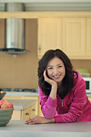 Young woman wearing pink smiling in her kitchen - Alex Mares-Manton
