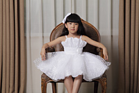 Young girl dressed up in white dress and sitting on nice chair - Alex Mares-Manton