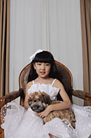 Young girl dressed up in white dress holding a puppy - Alex Mares-Manton