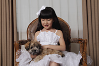 Young girl dressed up in white dress holding a puppy - Alex Mares-Manton