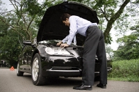 Businessman looking under hood of car - Asia Images Group