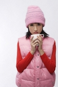 Young woman in pink hat and vest with coffee cup - Asia Images Group
