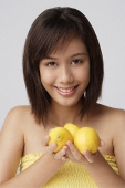 Young woman holding lemons - Asia Images Group
