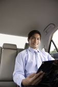 Businessman in backseat of car - Asia Images Group