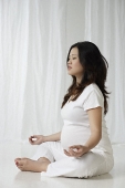 Pregnant woman meditating - Asia Images Group