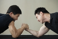 Two men arm wrestling - Asia Images Group