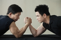 Two men locked in arm wrestling - Asia Images Group