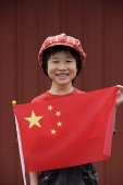 Portrait of little girl standing behind Chinese flag - Asia Images Group