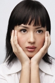 Portrait of woman with hands on face - Asia Images Group