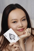 Young woman holding ace of spades card - Asia Images Group