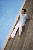 Man reclining by pool - Asia Images Group