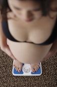 Top view of pregnant woman standing on scale - Asia Images Group