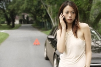 Angry woman on phone, broken car - Asia Images Group