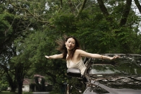 Woman hanging out car window - Asia Images Group