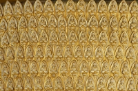 Structure covered with golden Buddhas sitting in lotus - Asia Images Group