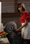 Waitress in diner taking out trash - Asia Images Group