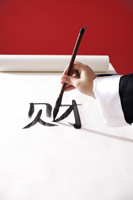 Woman writing Chinese calligraphy "Fortune" - Asia Images Group