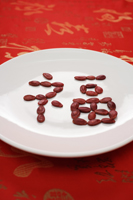Chinese character for "fortune" formed with red melon seeds - Asia Images Group
