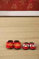 Still life of 2 pairs of red shoes on weaved mat - Asia Images Group