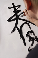 Man writing Chinese calligraphy, character for "Spring" - Asia Images Group