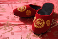 Still life of pair of red shoes on oriental design fabric - Asia Images Group