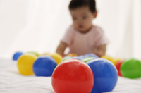 baby girl playing with balls - Asia Images Group