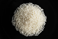 a pile of uncooked rice against a black plate - Asia Images Group