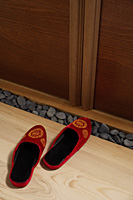 top view of red oriental slippers at door front - Asia Images Group