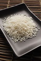 grains of uncooked rice on a square dish - Asia Images Group
