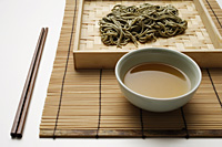 cooked soba noodles with sauce on bamboo tray and chopstick setting - Asia Images Group
