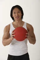 Chinese man holding medicine ball - Asia Images Group