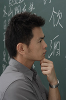 portrait of man thinking in front of chalk board - Asia Images Group