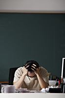 man stressed at desk - Asia Images Group