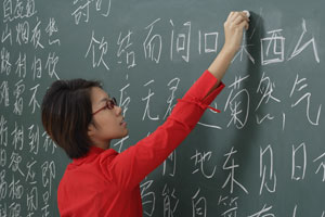 woman writing chinese characters on chalk board - Asia Images Group