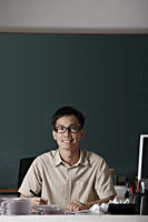 man sitting in front of chalk board - Asia Images Group