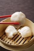 red chopsticks holding dimsum - Asia Images Group