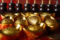 Close up of Chinese gold ingots and abacus. - Asia Images Group